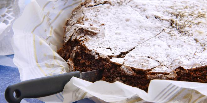 a deep dark chocolate cake with confectioner's sugar on top