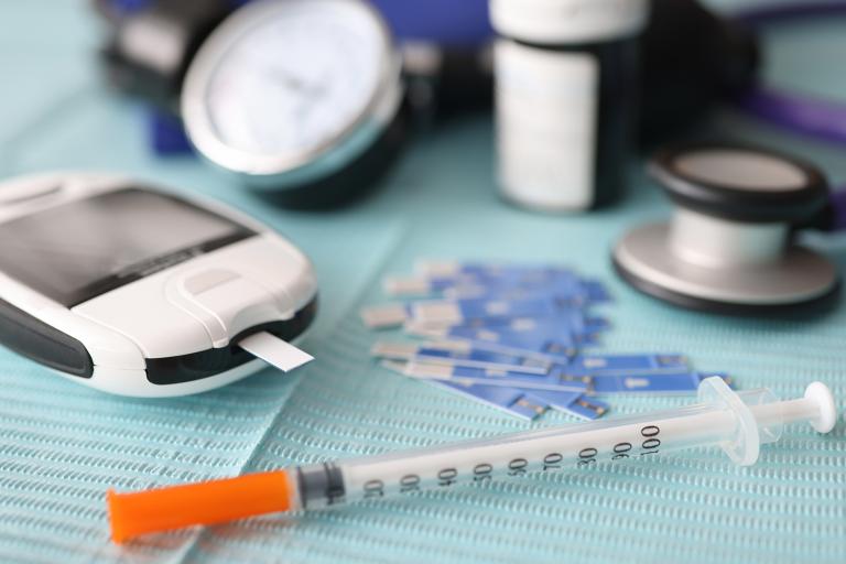 a diabetes testing strip and syringe