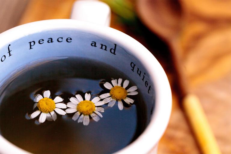 A cup of chamomile tea. The mug says "peace and quiet."