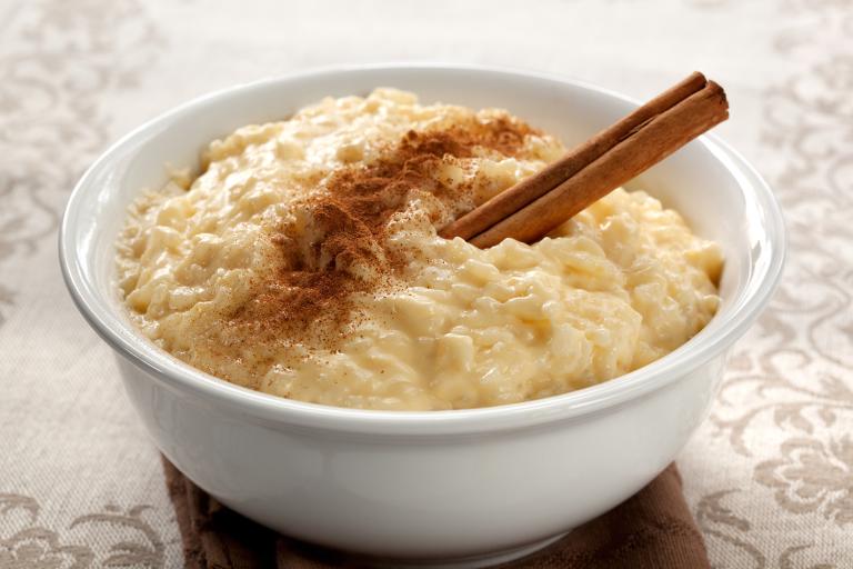 a bowl of sweetened rice pudding with cinnamon on top