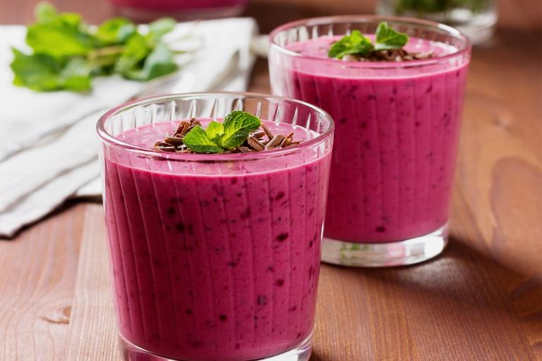 cups of berry yogurt smoothies with mint garnish